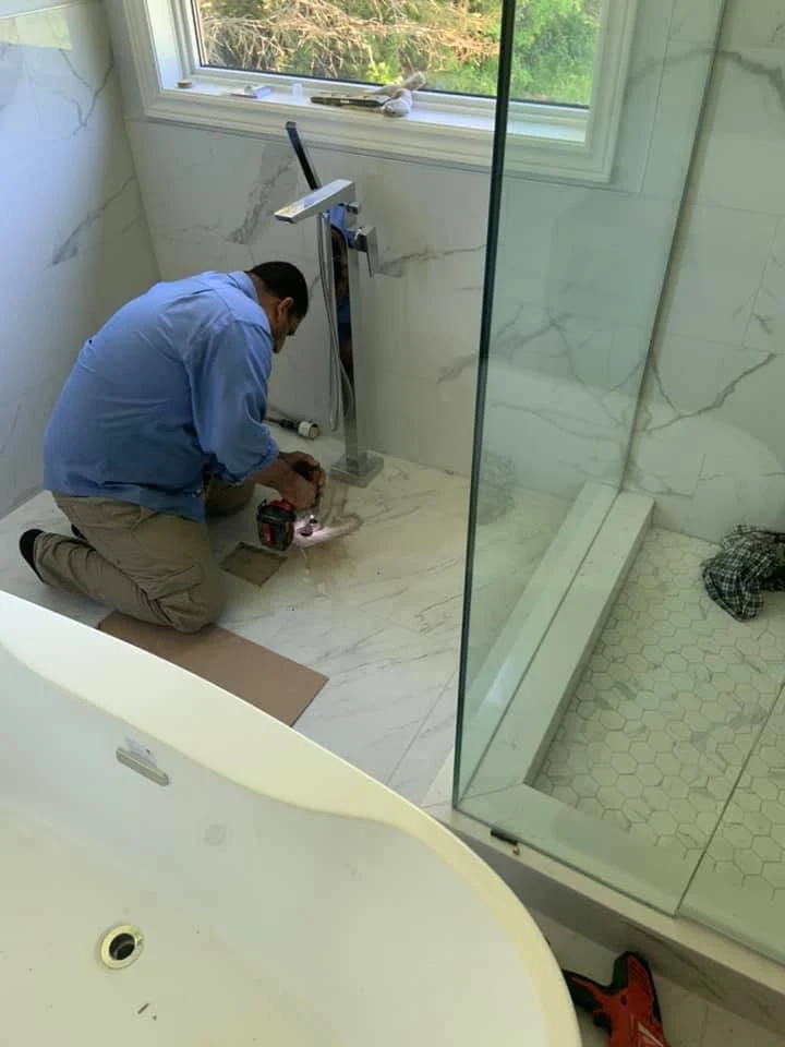 Plumber repairing a bathroom fixture in a residential home